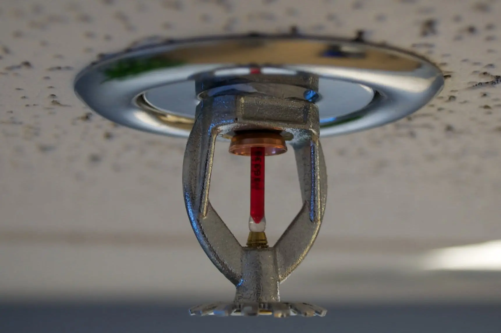 Pendent fire sprinkler head mounted in a commercial ceiling