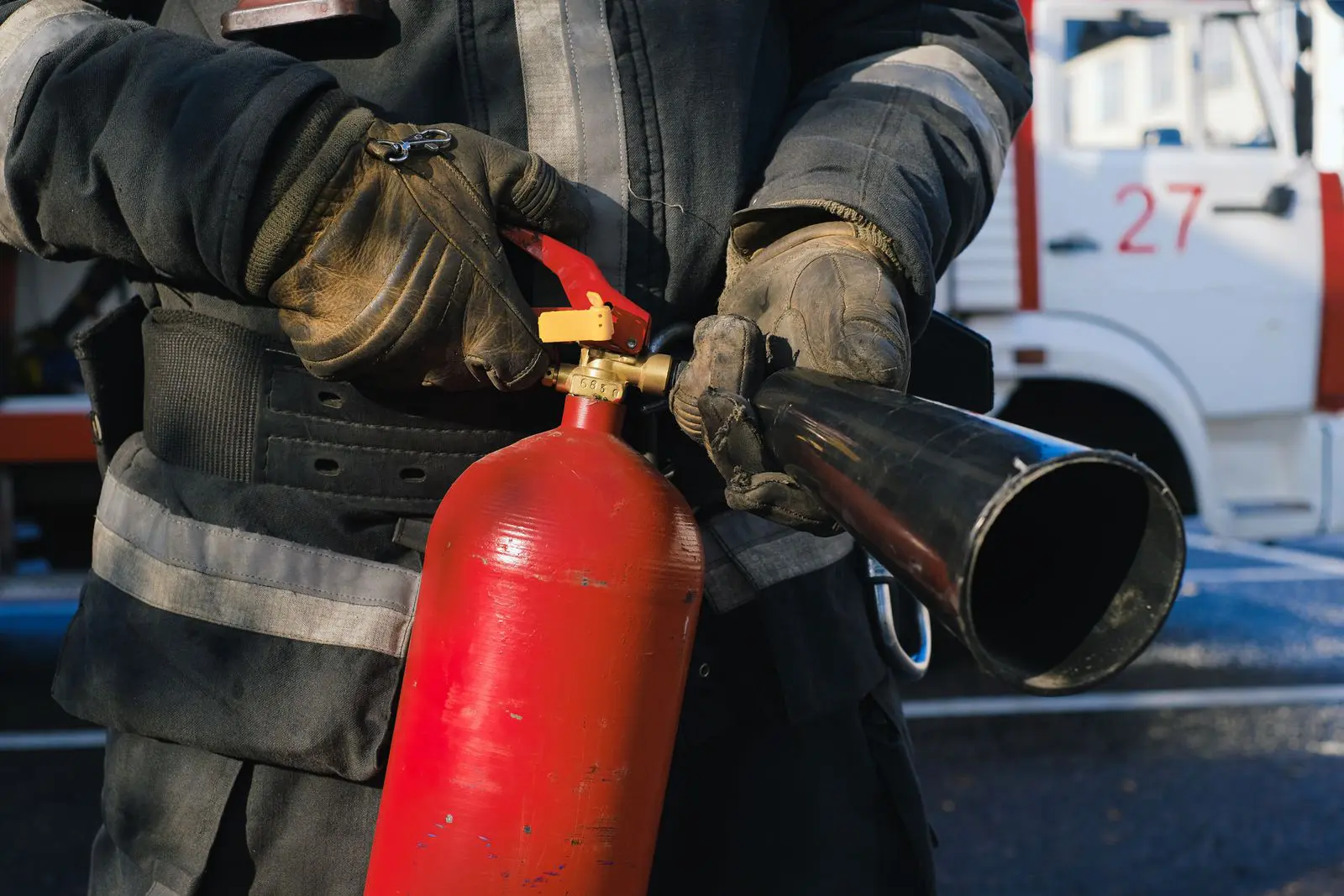 Firefighter in uniform holding a fire extinguisher, ready for 24/7 emergency response